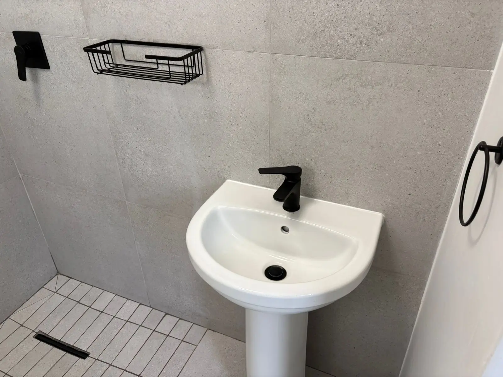 Completed basin vanity and tiled bathroom wall