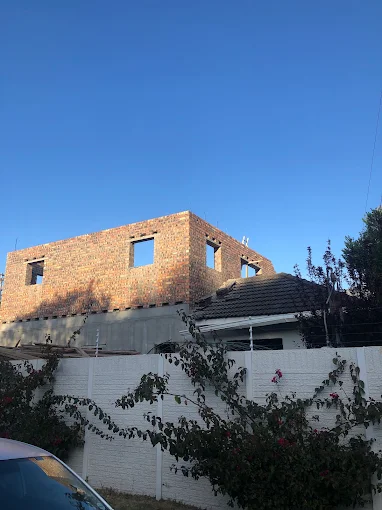 Street-side walls taken to full height with window openings formed