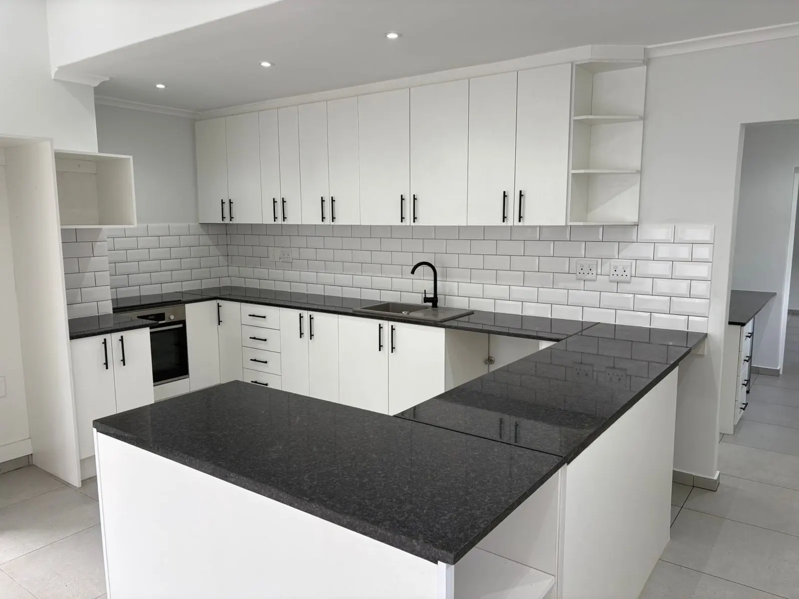 White kitchen cupboards with dark countertops