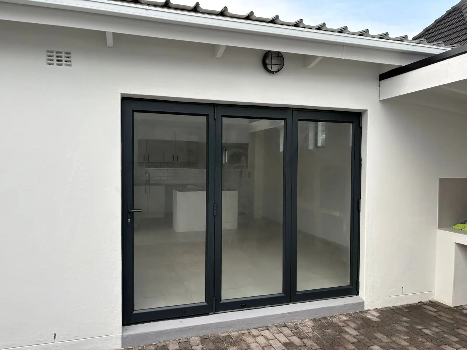 Black-framed sliding doors opening onto the courtyard