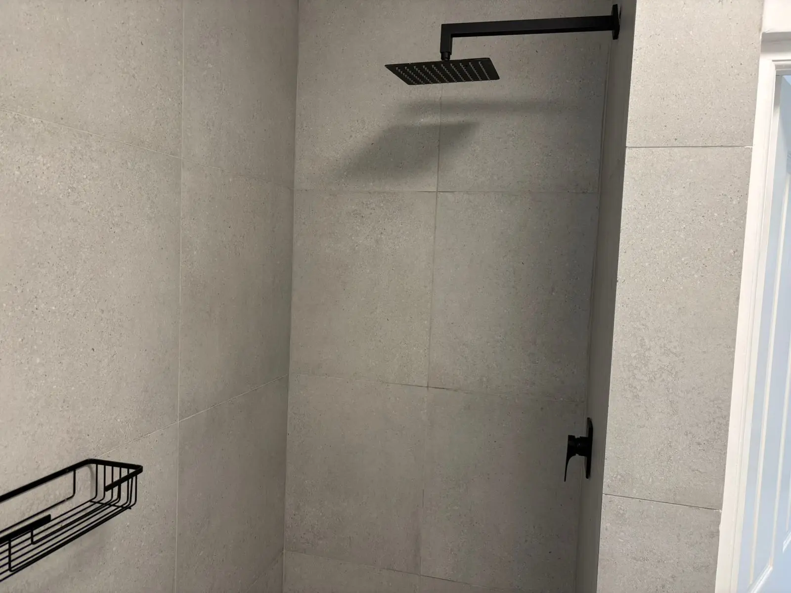 Tiled shower enclosure and black fittings