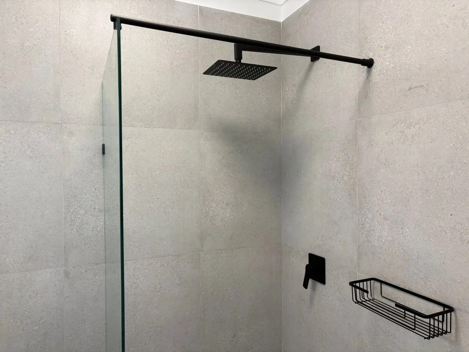 Glass shower screen and black rainfall shower fittings
